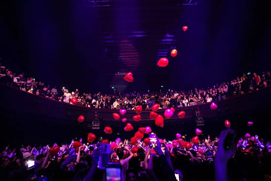 Le public sous une pluie de ballons cœurs
