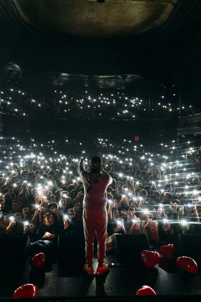 Un artiste face à la salle illuminée par les téléphones